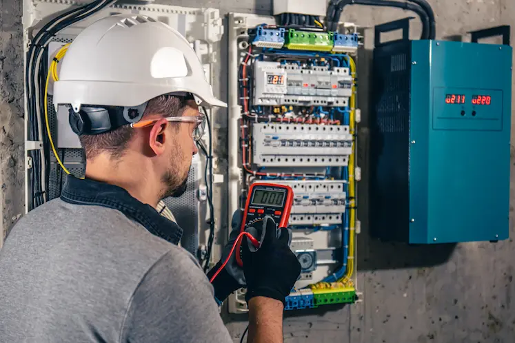Local electrician testing circuits in a fuse panel at a South East property