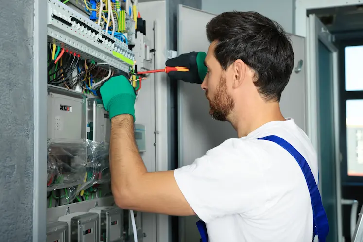 Local electrician working on electrical panel wiring at a North West property
