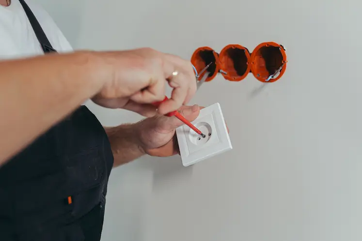 Local electrician mounting an electrical fixture at a North East property