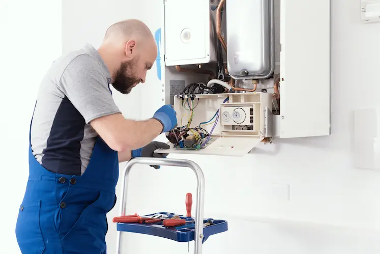 Local plumber repairing a boiler at a South East property
