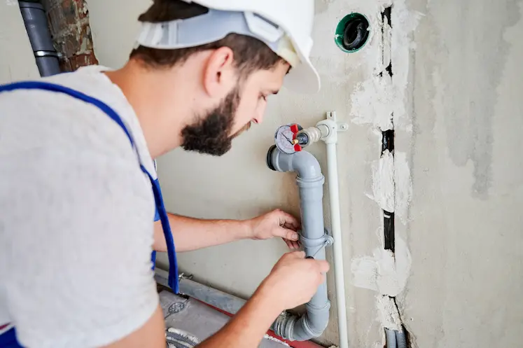 Local plumber fitting a valve on a pipe at an East of England property