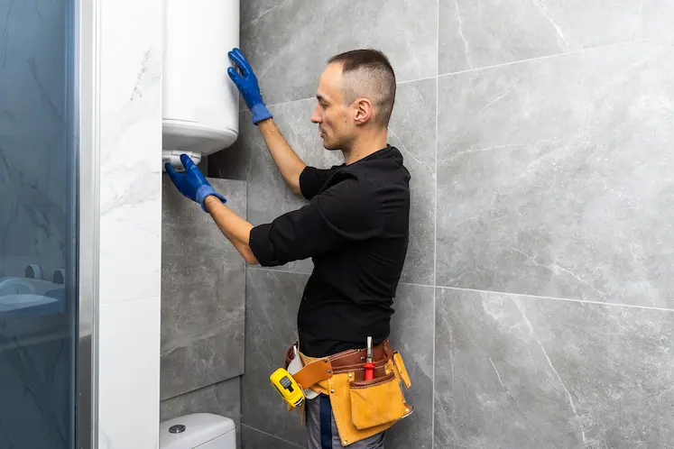 Local plumber installing a water heater at a South West property
